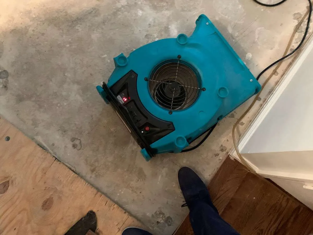 Air mover drying subfloor during Leak Detection & Repair in West Bend